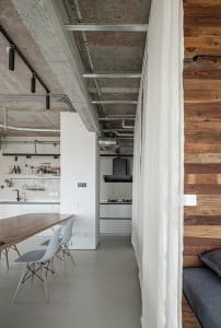 A modern kitchen and dining space with a large white table and chairs, sink, and oven, creating a functional and comfortable living area