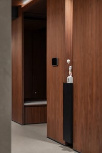 A dark hallway with wooden walls and floors, featuring two doors and a gloomy atmosphere