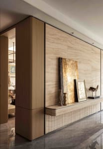 A modern living area with glass doors leading to a patio, featuring two couches, a chair, and a dining table with chairs, creating a comfortable and inviting atmosphere