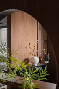Interior space with wooden walls, a wooden cabinet, potted plants, and a decorative vase