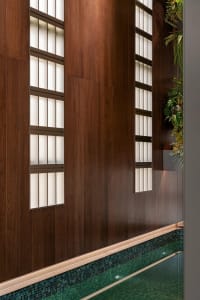 Warm and inviting interior space with wooden walls and floors, featuring two large windows that let in plenty of natural light