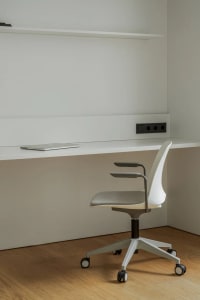 A clean and organized office space with a white desk, two chairs, and a professional ambiance