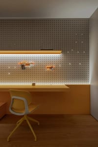 A casual office space with two chairs and orange wall-mounted guns, featuring a relaxed atmosphere