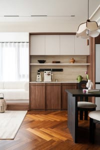 Cozy open-plan kitchen dining space with wooden cabinets, a coffee maker, and natural light