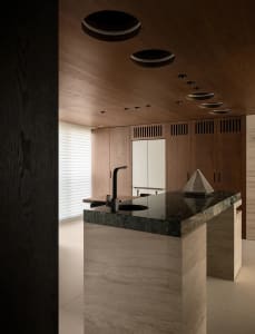 Modern kitchen with a large island countertop featuring marble, two sinks, and ample workspace and storage options