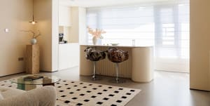 Inviting kitchen with white cabinets, black countertop, and a cozy seating area with stools at a countertop island