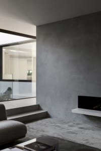 Open modern living area with natural light, two couches, and a fireplace in the background