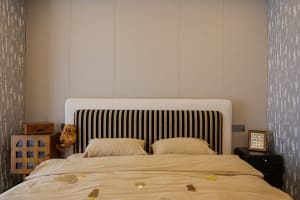 Cozy bedroom with a striped bed, two teddy bears, and a warm atmosphere