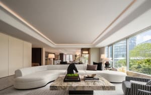 Open living area with a large couch, smaller couch, chairs, dining table, potted plants, and decorative vases in a clean and minimalist space with neutral tones