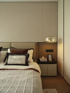 Cozy bedroom with a large bed, white bedding, and two lamps, set against a gray wall with brown accents