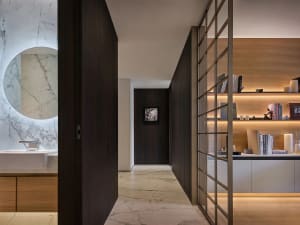 A hallway with wooden floors and walls, featuring two doors and a well-organized layout