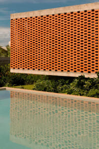 A photo of an orange wall with a pattern of squares, surrounded by potted plants in a relaxing and inviting environment