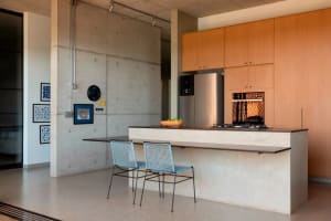 Bright modern kitchen with a countertop island, white cabinets, stainless steel appliances, and a clock on the wall