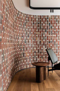 A cozy room with a brick wall, two chairs, and a dining table, creating a warm and inviting atmosphere