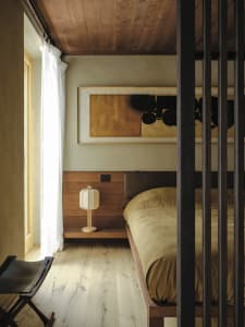 Cozy bedroom with a large bed, wooden headboard, nightstands, and a painting above the bed