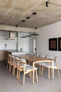 Cozy kitchen with a wooden dining table, chairs, and modern kitchen features like a sink and oven