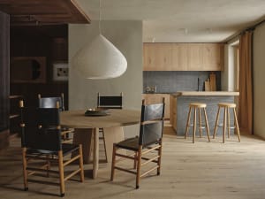 Open living area with a dining table, wooden kitchen cabinets, and a warm atmosphere