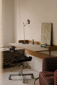 Office space with a desk, two chairs, a lamp, and a book, creating a productive and organized atmosphere
