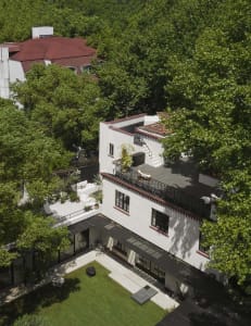 A modern building with white and red colors, featuring a balcony and contemporary design elements