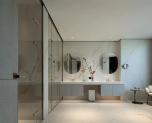 Modern bathroom with white walls, marble elements, and a large mirror above a sink, accompanied by a countertop and a cabinet, with two vases adding an elegant touch