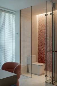 A modern bathroom with a white toilet and sink, two chairs, and a bright atmosphere