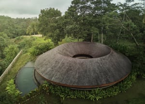A modern house with a circular shape surrounded by trees, providing a sense of tranquility and connection to nature