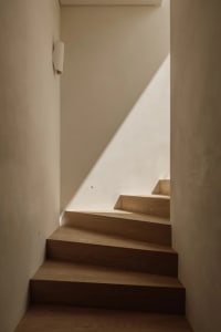 A classic staircase with two sets of wooden stairs, one on each side, in a historic building with a sense of nostalgia and charm