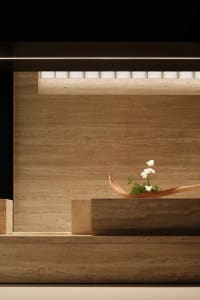 A wooden table with a vase and flowers in a warm and inviting atmosphere
