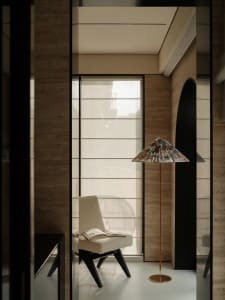 A modern living area with a chair near a window, stone walls, and a calm atmosphere