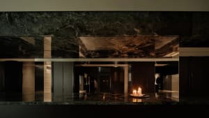 Elegant bathroom with a marble countertop, a large mirror, and two candles creating a warm and inviting atmosphere