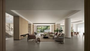 Bright and inviting living area with white interior, two couches, a chair, dining table, and potted plants