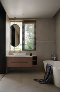 Bathroom with a sink, mirror, and bathtub, featuring two windows and a potted plant