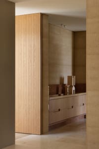 A tan-colored room with a large wooden cabinet, brown door, and two other doors, featuring a sink and a functional space