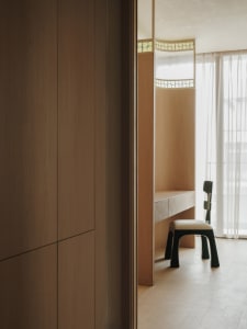 Small room with wooden walls and floors, featuring a desk between two chairs, creating a warm and inviting workspace