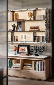 A well-organized bookshelf filled with various books of different sizes, arranged in an orderly manner on a wooden bookshelf in a cozy and intellectual environment