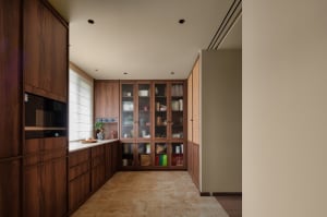 Clean and organized kitchen with wooden cabinets, tile flooring, and various kitchen items on display