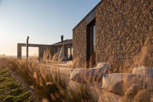 A relaxing outdoor living space with two couches and two chairs on a patio, surrounded by natural surroundings