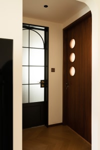 A warm and inviting doorway with a brown wooden frame and decorative elements, leading to another room in a residential home