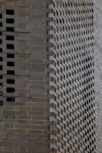 A brick wall with a unique pattern of bricks, made of stone, on a building's exterior