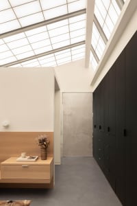 A modern study space with a wooden desk, two cabinets, and a vase on the desk, featuring a focus on functionality and simplicity
