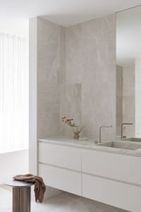 Bathroom with white marble walls and floors, two sinks, and marble countertops, conveying luxury and elegance