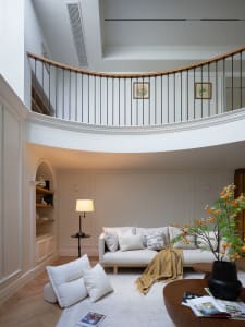 A bright and inviting open concept living area with a white couch, two chairs, a dining table, and a potted plant, emphasizing comfort and functionality