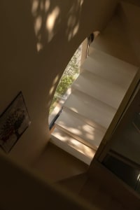 A photo of a staircase with wooden steps, leading to another level in a building, with a sense of depth and movement