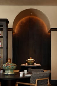 A dining area with a wooden table and chairs, set with various dishes and wine glasses, creating a warm and cozy atmosphere