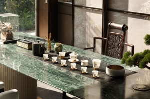 A well-lit dining room with a marble table, chairs, and decorative cups and bowls