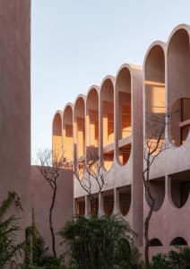 A modern building with a curved concrete structure and soft, diffused lighting creating a warm and inviting atmosphere