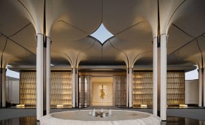 A modern lobby with a circular pool, white surfaces, and natural light from windows, featuring comfortable seating and a clean design