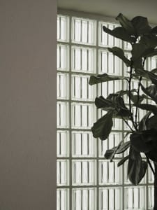 A cozy room with a large window, a potted plant, and natural light