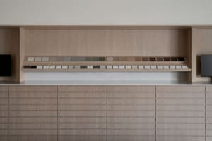 A modern kitchen with a wood cabinet, patterned tiles, and open drawers, featuring a functional and organized design