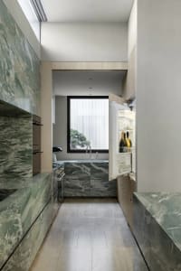 Well-lit kitchen with a white refrigerator, sink, and marble countertop, set against a bright and airy background